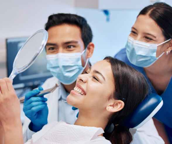 A smiling woman sits comfortably in a dentist's chair at Copperfield Dental, conveying a positive dental experience.